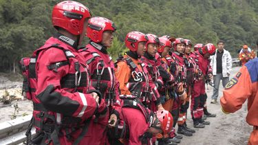 Fire and rescue personnel assemble before carrying out rescue operations on a section of a road leading to Gyirong Port which was damaged after a mudslide two days earlier, in Gyirong County, in China’s western Tibet region on August 28, 2026.  
CNS / AFP