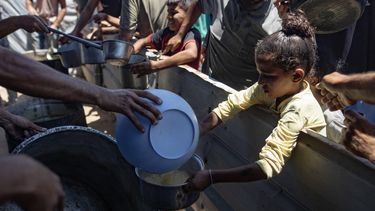 epaselect epa12247569 Internally displaced Palestinians gather outside a charity kitchen to receive limited food rations amid the lack of food availability, in Gaza City, 19 July 2025.  EPA/HAITHAM IMAD