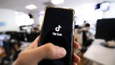 This photograph taken on April 19, 2024 shows a man holding a smartphone displaying the logo of Chinese social media platform Tiktok in an office in Paris 
Antonin UTZ / AFP