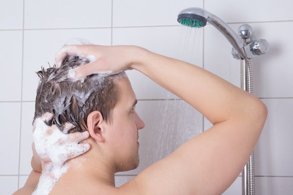 Een foto van een man die zijn haar wast