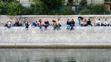 Een foto van mensen die op de hoge kade van de Seine in Parijs (Frankrijk) zitten te genieten.