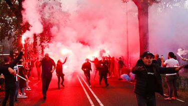 Een foto van supporters van Willem II die de spelersbus onthalen