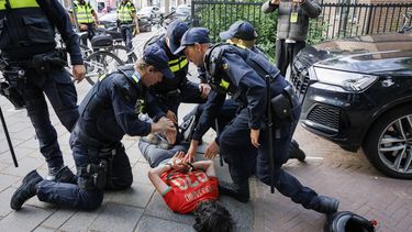 DEN HAAG - Politieagenten arresteren een persoon terwijl leden van de Mobiele Eenheid en een waterkanon worden ingezet in in de Schilderswijk nadat het nationale elftal op het WK tegen Nederland heeft gewonnen. Supporters van Marokko droegen een Marokkaanse vlag met zich mee, werd er getoeterd en vuurwerk afgestoken. JOHN VAN DER TOL / ANP