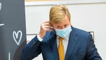 Een foto van koning Willem-Alexander met een mondkapje