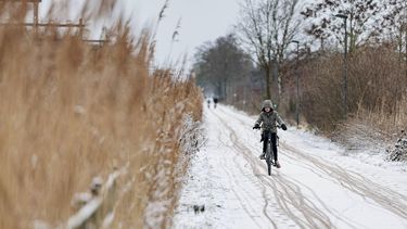 ENSCHEDE - Een fietser op een besneeuwd fietspad. In het hele land geldt code geel omdat het plaatselijk glad kan zijn door sneeuwresten en bevriezing van natte wegen. EMIEL MUIJDERMAN / ANP