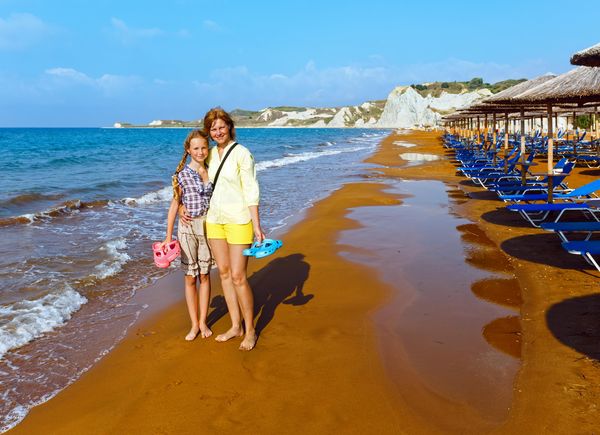 Een moeder en dochter maken een strandwandeling op Xi beach. / Colourbox