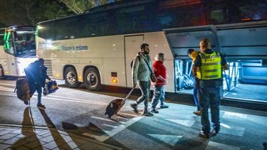 TER APEL - Asielzoekers bij het aanmeldcentrum, waar de opvanglocatie overvol is. Na lang wachten verschenen er uiteindelijk toch nog bussen om de mensen naar een locatie elders te brengen. MARCEL J. DE JONG / ANP
