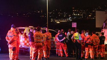 Emergency services workers gather at the scene after a shooting incident at Bondi Beach in Sydney on December 14, 2025. Two gunmen opened fire at Sydney's Bondi Beach on December 14, killing 11 people and wounding multiple others in a 