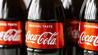 Close-up van glazen frisdrank Coca-Cola-flessen met het herkenbare rode etiket en witte 