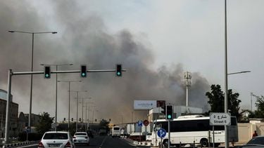Motorists drive past a plume of smoke rising from a reported Iranian strike in the industrial district of Doha on March 1, 2026. AFP correspondents and residents heard fresh explosions across the Gulf cities of Dubai, Abu Dhabi, Doha and Manama on March 1, as Iran pressed on with its retaliatory campaign for a second day.