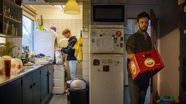 ILLUSTRATIE - Een student haalt zijn kleren uit de droger in de gemeenschappelijke keuken van een studentenflat, terwijl een andere student een lege bierkrat verplaatst. **OPMERKING VAN DE REDACTIE: DEZE FOTO MAG ALLEEN REDACTIONEEL WORDEN GEBRUIKT** ANP RAMON VAN FLYMEN