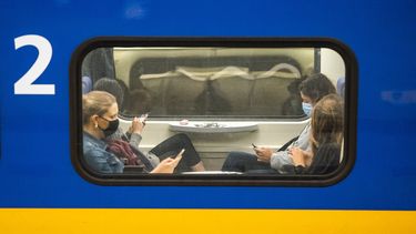Openbaar vervoer NS trein druk mensen op telefoon