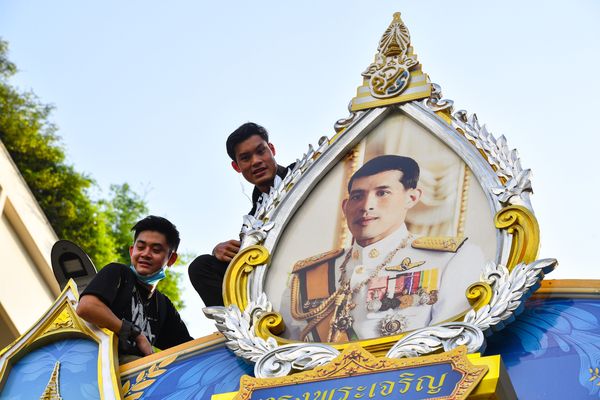 Een foto van studenten bij een portret van de koning van Thailand