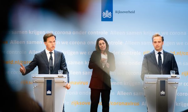 Een foto van premier Rutte, gebarentolk Irma en minister de jonge tijdens een persconferentie