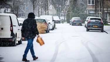 MAASDAM - Mensen lopen over een besneeuwde straat. In het hele land geldt code geel voor gladheid door sneeuw of bevriezing van wegen. JEFFREY GROENEWEG / ANP