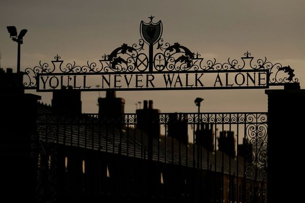 Een foto van een You Never Walk Alone-poort in de duisternis, passend bij de coronamaatregelen in Liverpool