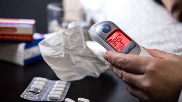 ILLUSTRATIEF - Een oorthermometer geeft koorts aan bij een vrouw met griepklachten. Wanneer er twee weken achter elkaar minstens 53 griepgevallen op de 100.000 mensen worden geregistreerd, is er sprake van een griepepidemie. ANP ROB ENGELAAR