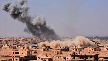 Rook stijgt uit boven gebouwen in de buurt van Bughayliyah, Syrië, in de strijd tegen IS. Foto: AFP