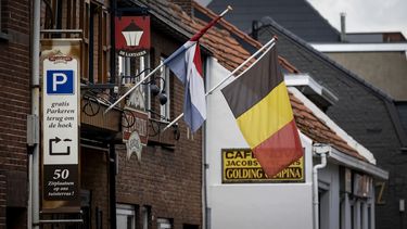 Een foto van vlaggen op de grens van Nederland en België