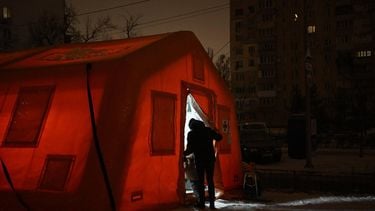 People enter an emergency service tent set up for those whose homes are without electricity or heating following Russian missile and drone attacks on Ukrainian energy infrastructure, in a residential neighborhood of Kyiv on January 22, 2026  amid the Russian invasion in Ukraine. 
Genya SAVILOV / AFP