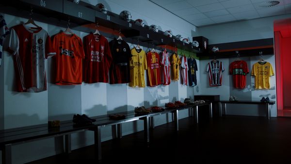 Een foto van een kleedkamer vol voetbalshirts
