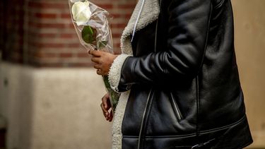 Een leerling komt aan met bloemen bij het Design College, waar de schietpartij plaatsvond. Foto: anp