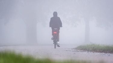 MAASDAM - Een fietser op een fietspad tijdens dichte mist. Het KNMI heeft code geel afgegeven vanwege de dichte mist. Verspreid over het land kan het zicht daardoor plaatselijk minder dan 200 meter zijn. ANP JEFFREY GROENEWEG