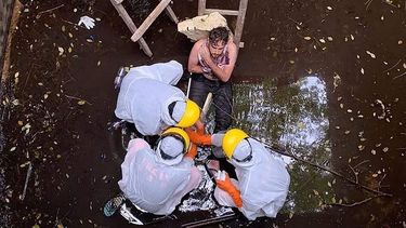 Een foto van reddingswerkers die een man helpen in een waterput.