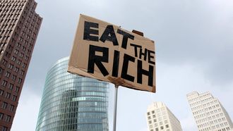 A demonstrator holds a sign reading "Eat the rich" during a protest against increasing rent prices, discrimination in the housing market, forced evictions in Berlin, Germany on June 1, 2024 
Adam BERRY / AFP