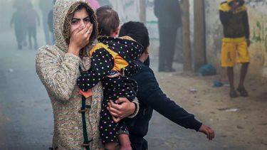 2023-11-23 07:37:57 A woman holding a child flees following an Israeli strike in Rafah in the southern Gaza Strip on November 23, 2023, amid ongoing battles between Israel and the Palestinian militant group Hamas. 
Mohammed ABED / AFP