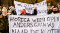 Een spandoek met 'Horeca weer open anders gaan wij naar de kloten'.