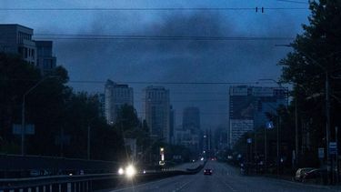 Vehicles are driven along a road as smoke rises above buildings in the background following an air attack in Kyiv on May 14, 2026, amid the Russian invasion of Ukraine. Large-scale Russian strikes on Kyiv killed one person and wounded at least 31 others, city authorities said on May 14, 2026, as Moscow ramped up attacks on Ukraine following a short-lived ceasefire.
Serhii Okunev / AFP