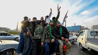 Anti-government fighters cheer from the back of a car near Umayyad Square in Damascus on December 8, 2024. Islamist-led rebels declared that they have taken Damascus in a lightning offensive on December 8, sending President Bashar al-Assad fleeing and ending five decades of Baath rule in Syria.
LOUAI BESHARA / AFP