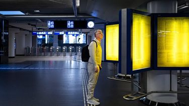 AMSTERDAM - Een reiziger bekijkt informatieborden in de hal van treinstation Amsterdam Centraal tijdens een staking. NS-personeel heeft het werk neergelegd in regio's Noordwest en Oost. ANP RAMON VAN FLYMEN