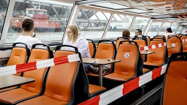 Op deze foto zie je een rondvaartboot waar stoelen bezet worden gehouden om afstand te kunnen houden.