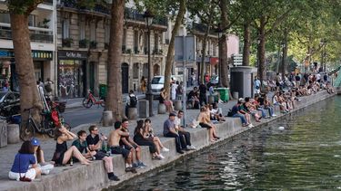 epa13140292 People cool off along the banks of the Canal Saint-Martin in Paris, France, 29 July 2026, as the country grappled with its fourth major heatwave of the summer.  EPA/MOHAMMED BADRA