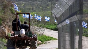 Palestinian farmers from the village of Burqa, drive their tractor past a fence decorated with Israeli flags installed by Jewish settlers after they announced their control over the historical Al-Masoudiya Ottoman era train station, which operated between the Palestinian cities of Nablus and Tulkarm in the 1920s, just north of the city of Nablus, in the northern Israeli-occupied West Bank on February 15, 2026. Violence in the Palestinian West Bank, which Israel has occupied since 1967, has soared since the Hamas attack on Israel triggered the Gaza war in October 2023. New Israeli measures taken on the weekend of February 9, 2026, for the occupied West Bank, are expected to accelerate the territory's annexation, ease land purchases by settlers and push Palestinians into increasingly isolated enclaves.
Jaafar ASHTIYEH / AFP