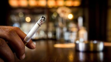 Een foto van een hand met een brandende sigaret. Zorgen Trimbos: meer twintigers zijn gaan roken.