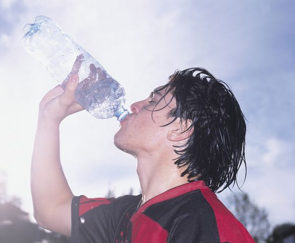 Op deze foto zie je een voetbalspeler water drinken