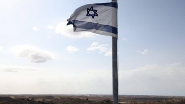 An Israeli flat flutters on a pole across the border with Gaza in southern Israel on October 9, 2025. Israel and Hamas on October 9 agreed a Gaza ceasefire deal to free the remaining living hostages, in a major step towards ending a war that has killed tens of thousands of people and unleashed a humanitarian catastrophe.
AHMAD GHARABLI / AFP