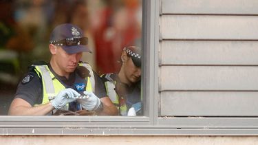 Op deze foto zie je politie in Australie tijdens een festival iemands pillen uit een tas controleren.