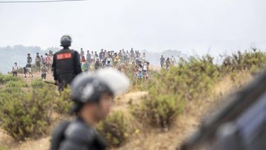 epa13143773 Members of the Moroccan security forces and civilians who returned from Spain gather at the site of clashes at the Bab Sebta border crossing near Fnideq, Morocco, 31 July 2026. The unrest erupted as thousands of migrants attempted to cross into Ceuta and clashed with Moroccan security forces.  EPA/JALAL MORCHIDI