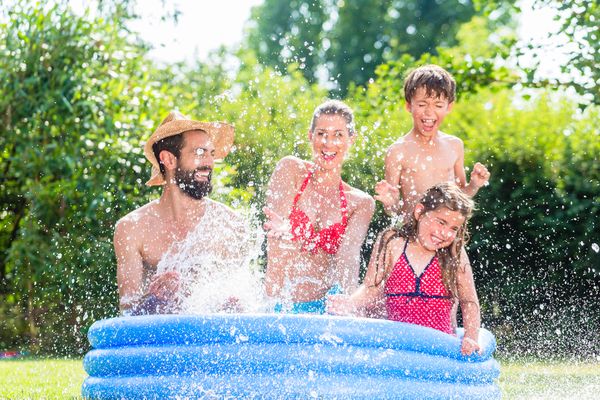 Vrolijke familie in een zwembad in de tuin