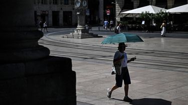 A pedestrian uses an umbrella to protect herself from the sun as she walks in the street in Bordeaux, southwestern France on June 23, 2026, as France experiences a heatwave. 
Christophe ARCHAMBAULT / AFP