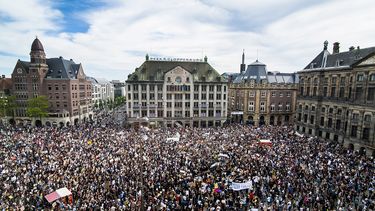 Op deze foto zie je demonstranten op de Dam in Amsterdam.
