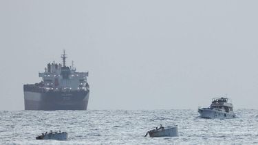 A boat bearing symbols of one of the vessels belonging to the Gaza-bound aid flotilla (L) and intercepted by the Israeli navy, is motored towards the Israeli port of Ashdod, about 40 kilometres south of Tel Aviv, on May 19, 2026. The Global Sumud Flotilla vessels are the latest in a string of attempts by activists to breach Israel's blockade of the Palestinian territory, with the last convoy intercepted by Israeli forces. Israel controls all entry points into Gaza, which has been under an Israeli blockade since 2007. During the Gaza war, triggered by Hamas's October 2023 attack on Israel, the territory has suffered severe shortages of food, medicine and other essential supplies, with Israel at times halting aid deliveries entirely. The Israeli ministry rejected claims that Gaza was facing aid shortages. 

Jack GUEZ / AFP
