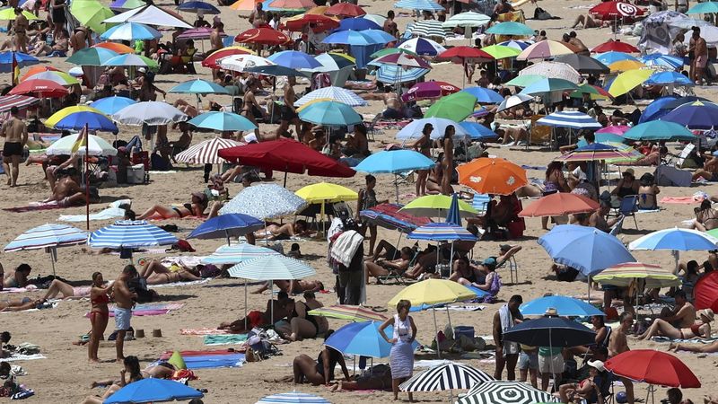 epa12202702 People cool off at the beach during a heat wave in Oeiras near Lisbon, Portugal, 28 June 2025.  EPA/ANTONIO COTRIM