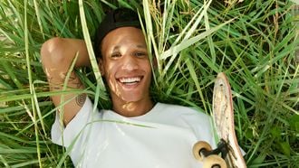 Jongen ligt in het gras en is gelukkig