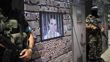Members of the al-Qassam Brigades, Hamas' armed wing, stage a performance in which they stand guard outside a mural depicting a prison cell imitating where Israeli soldier Hadar Goldin would have been held, during a presentation on September 2, 2015 at a main square in the centre of Gaza City. Lieutenant Goldin was killed during the 2014 Gaza war and Hamas is reportedly holding his body parts.  AFP PHOTO / MOHAMMED ABED 
MOHAMMED ABED / AFP