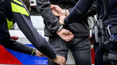 ILLUSTRATIEF - Politieagenten slaan iemand in de boeien op straat. ANP EMIEL MUIJDERMAN